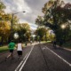 People running, walking and cycling on a tree-lined road