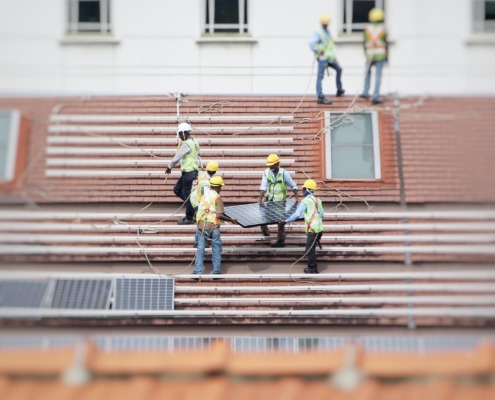 Workers in hard hats installing solar panels