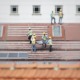 Workers in hard hats installing solar panels